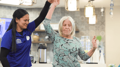 Staff assisting a resident in a cheerful setting