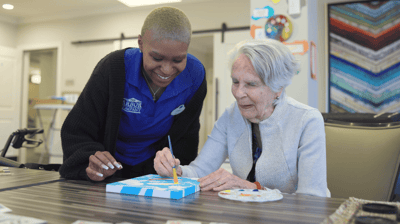 Staff assisting a resident with an art project
