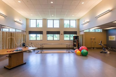 Bright therapy room with exercise equipment and colorful balls