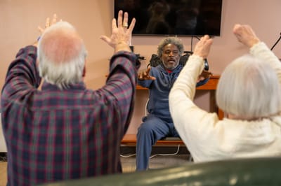 Residents participating in an exercise activity led by a staff member