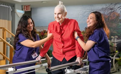 Residents participating in a therapy session with staff assistance