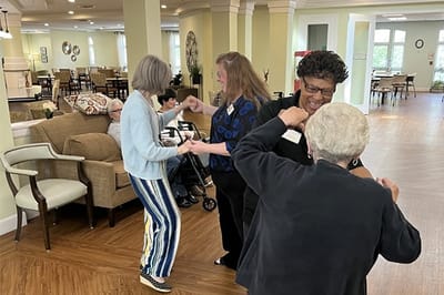 Residents and staff engaging in a lively activity in a common area