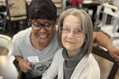Staff member smiling with a resident in a common area