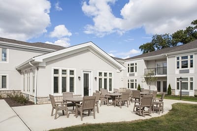 Exterior view of a senior living facility with outdoor seating