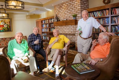 Five male residents enjoying drinks in a cozy lounge