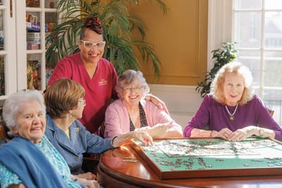 Residents and staff engaging in a puzzle activity