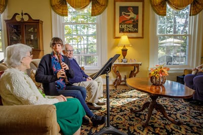 Residents enjoying a musical performance in a common area