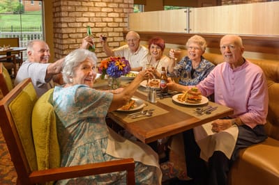 Residents celebrating at a dining table with food and drinks
