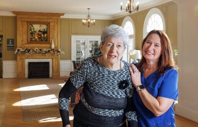 Resident and staff member smiling in a common area