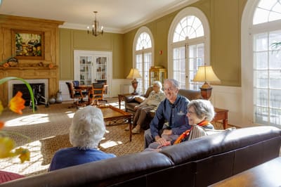 Staff member interacting with residents in a cozy common area