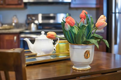 A vase of tulips on a table in a kitchen.