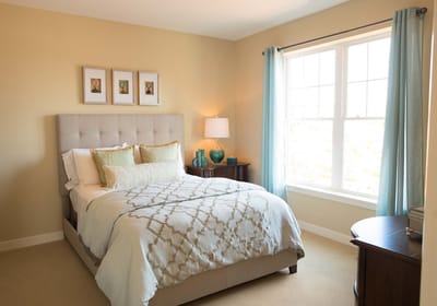 Cozy bedroom with a neatly made bed and natural light