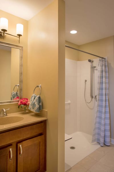 A well-lit bathroom with shower and sink area