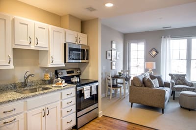 Cozy living area with kitchen in a senior living unit