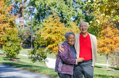 Two seniors smiling in a colorful outdoor park