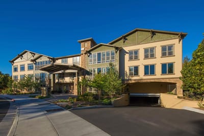 Exterior view of a senior living facility with landscaped entrance