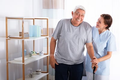 Caregiver assisting a senior resident in a bright room