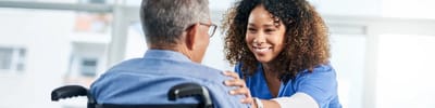 Healthcare worker interacting with a resident in a bright indoor setting
