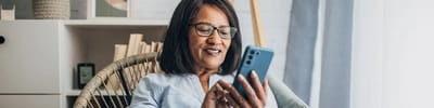 Senior woman using a smartphone in a cozy setting