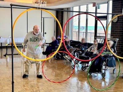 Residents participating in a group activity with hula hoops