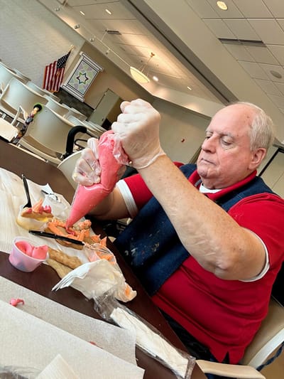 A resident decorating pastries in a common area