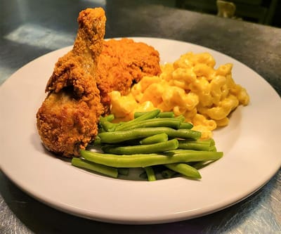 Dish of fried chicken with green beans and macaroni and cheese