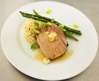 A beautifully plated meal with meat, rice, and vegetables