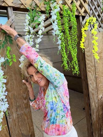 Resident enjoying a sunny outdoor space adorned with flowers