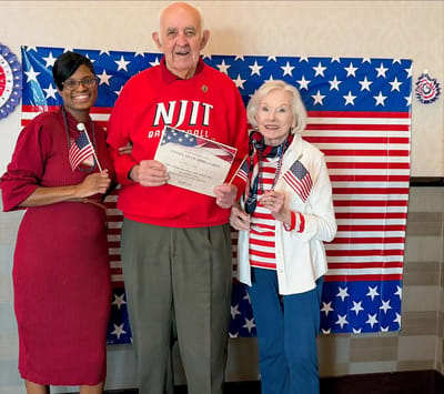 Residents celebrating with flags and certificates