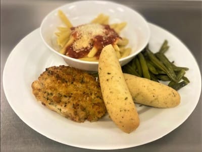 A well-prepared plate of pasta, chicken, and green beans