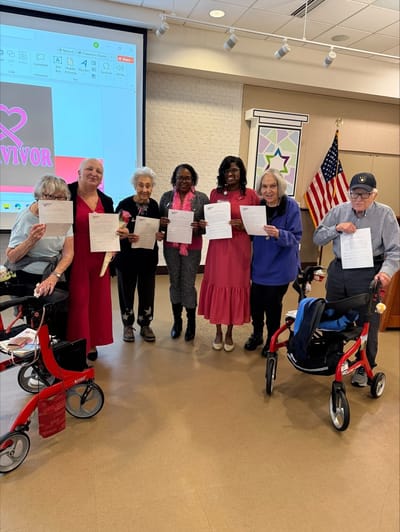 Residents posing with certificates in a common area