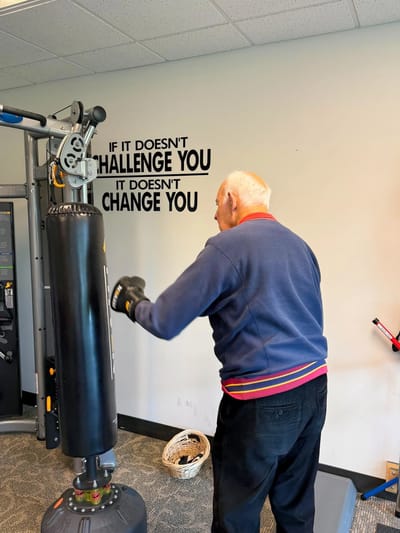 Senior resident boxing in an exercise room