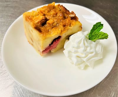 A piece of dessert with whipped cream and mint garnish