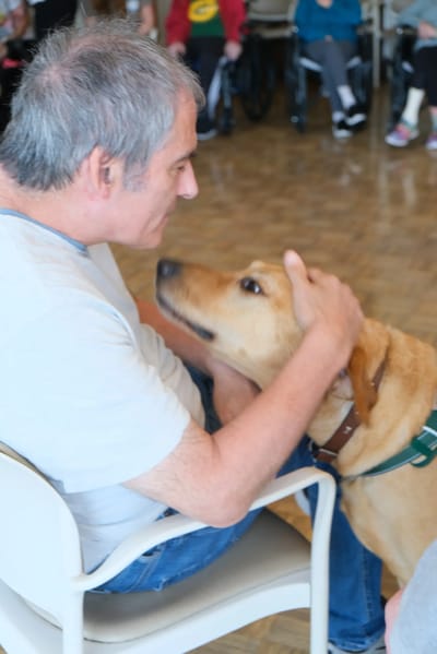 Resident interacting with a dog in a common area
