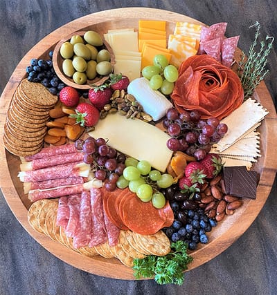 A gourmet charcuterie board with various meats, cheeses, and fruits
