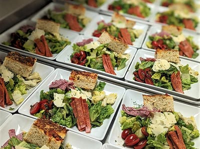 Plated meals with salads and bread in a dining setting