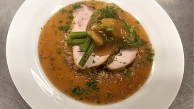 A plated meal consisting of turkey, rice, and asparagus