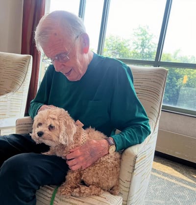Senior resident enjoying time with a dog in a cozy setting
