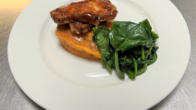A plated meal featuring chicken, sweet potato, and spinach