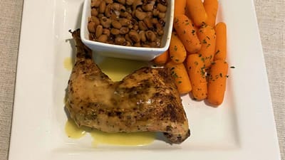 A plated meal featuring chicken, beans, and carrots.