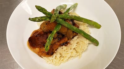 Dinner plate with chicken and asparagus on rice
