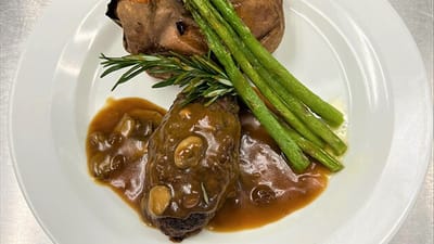 Plated meal with meatloaf, baked potato, and asparagus