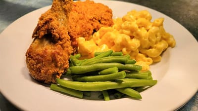 A plate of fried chicken, macaroni and cheese, and green beans