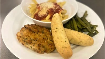 A plated meal with pasta, chicken, and green beans