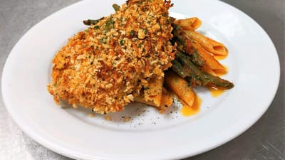 A plated meal of baked chicken and pasta