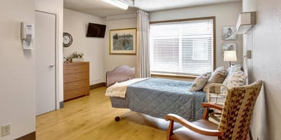 Private resident room with bed and chair