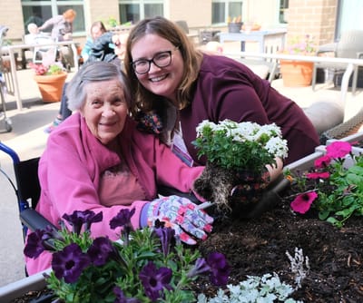 Residents and staff gardening together outdoors