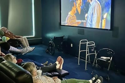 Residents enjoying a movie in a cozy common area