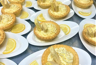 Plated lemon tart desserts with wafers and lemon slices