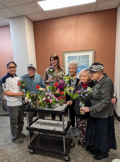 Residents and staff arranging flowers in a common area